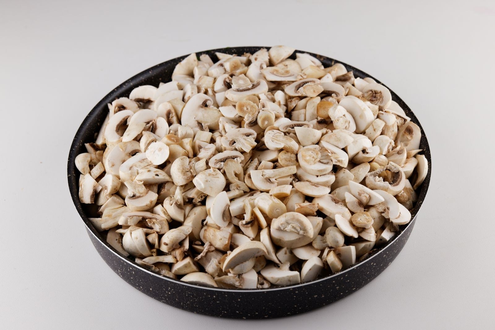 Bowl of evenly sliced white mushrooms