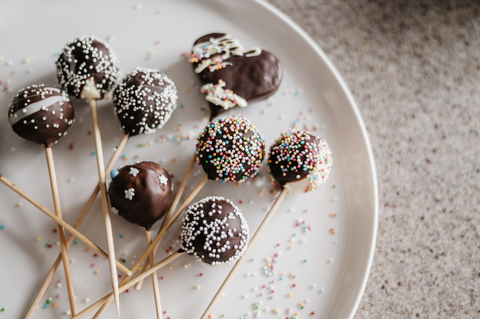 Chocolate cake pops with sprinkles on a plate
