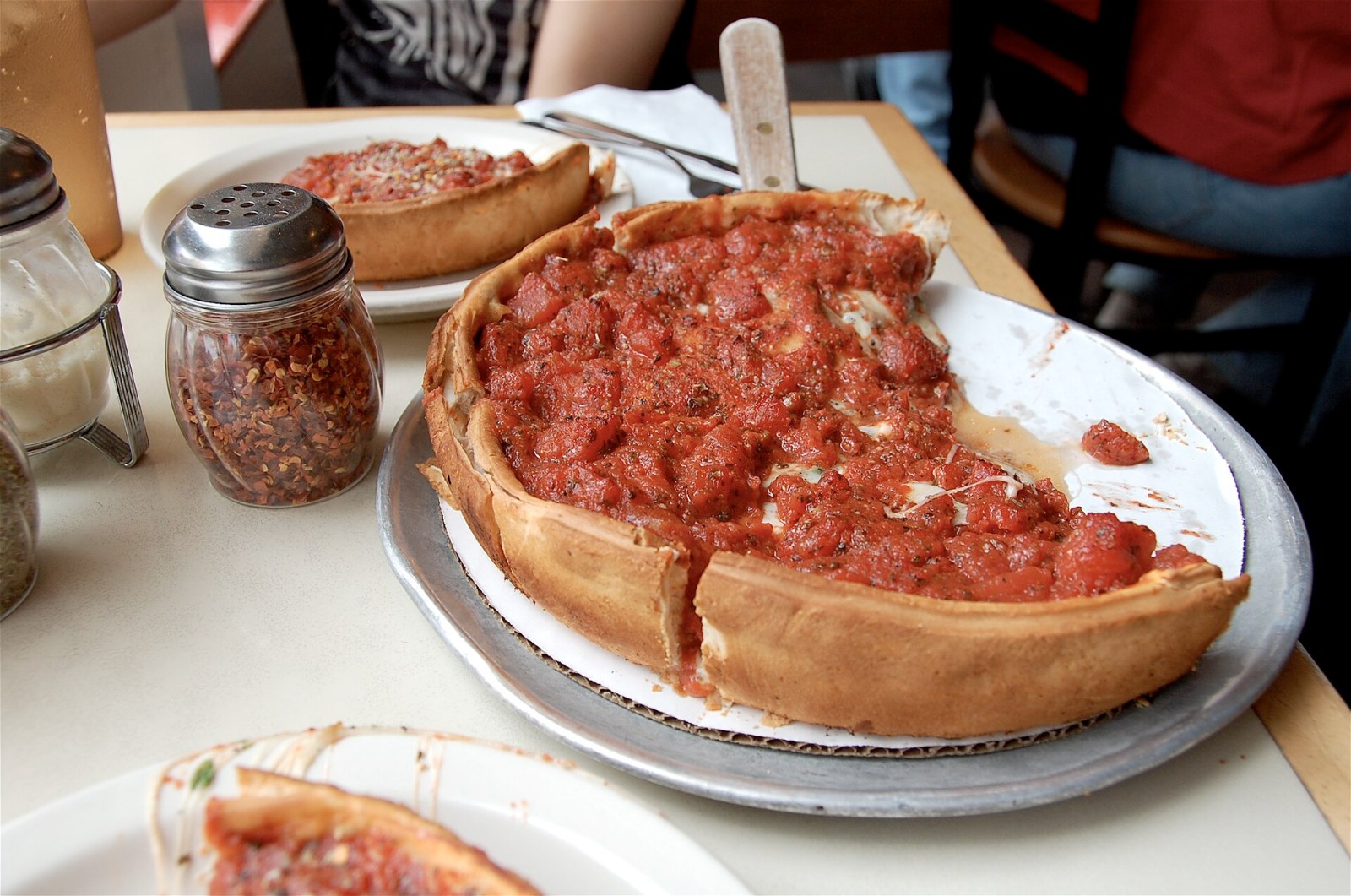 Chicago deep dish with a tall buttery crust and chunky tomato sauce on top