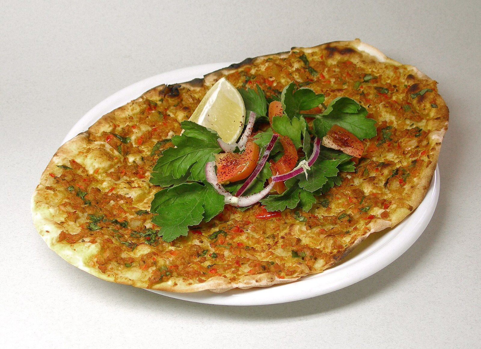 Turkish lahmacun flatbread with spiced lamb, parsley, onion and lemon