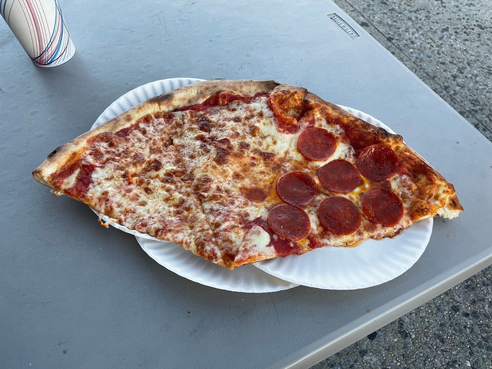 Pizza styles: a big foldable New York style pepperoni slice on a paper plate