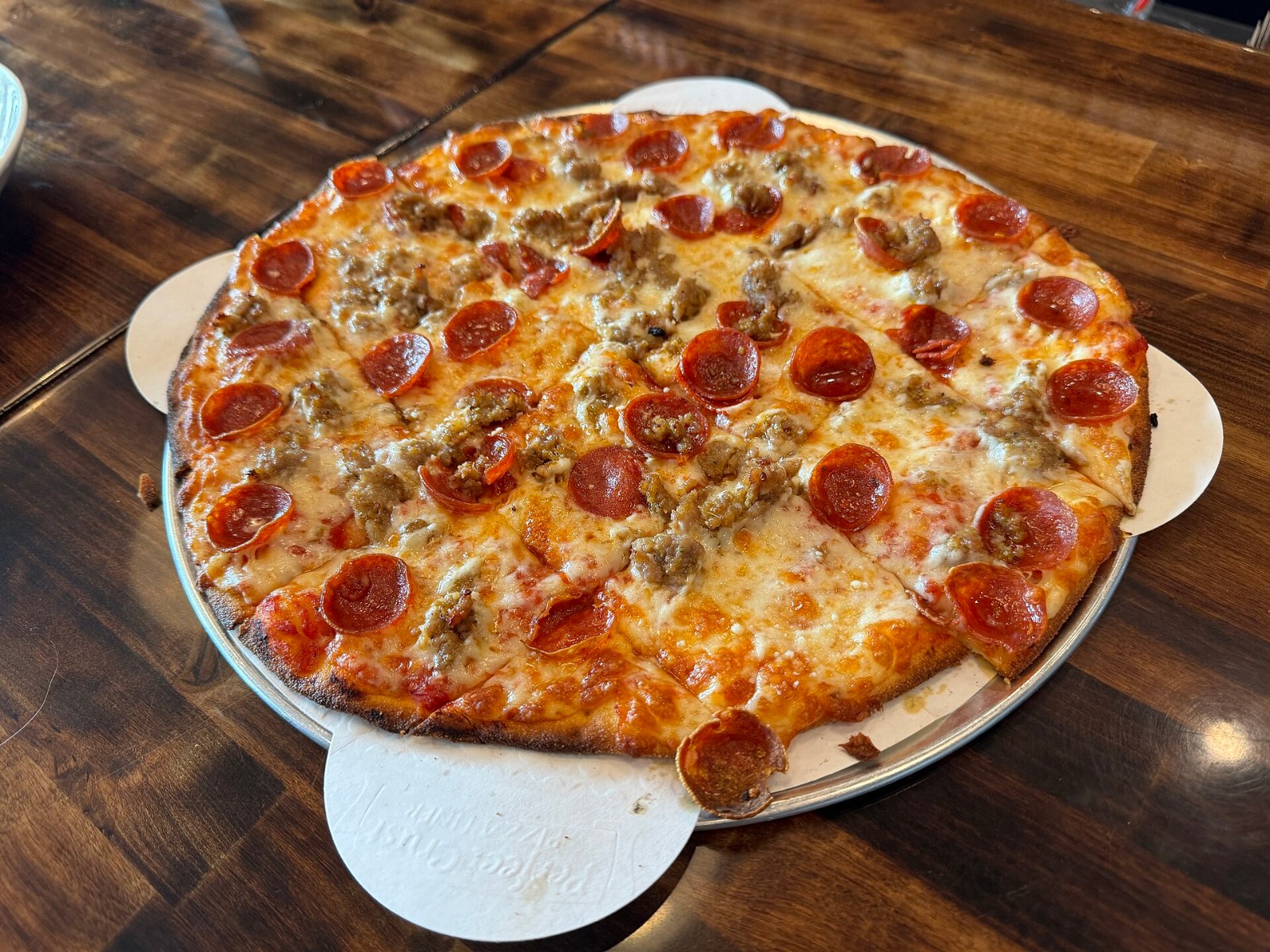 Pizza styles: thin crispy tavern style pizza with pepperoni and sausage cut into squares