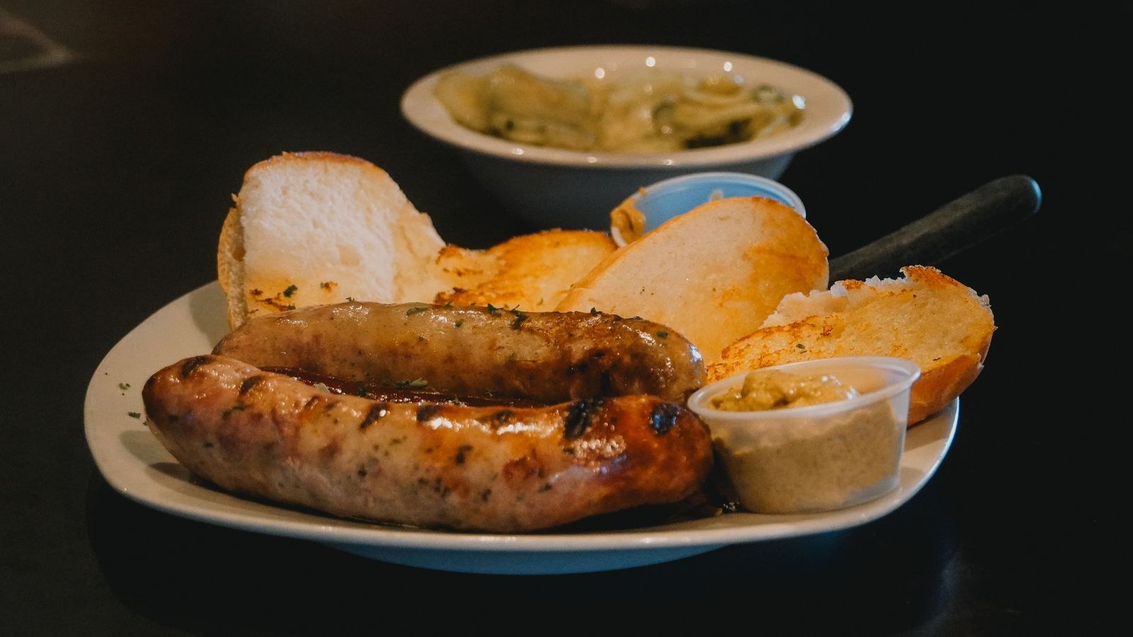 Grilled bratwurst with bread and dipping sauce