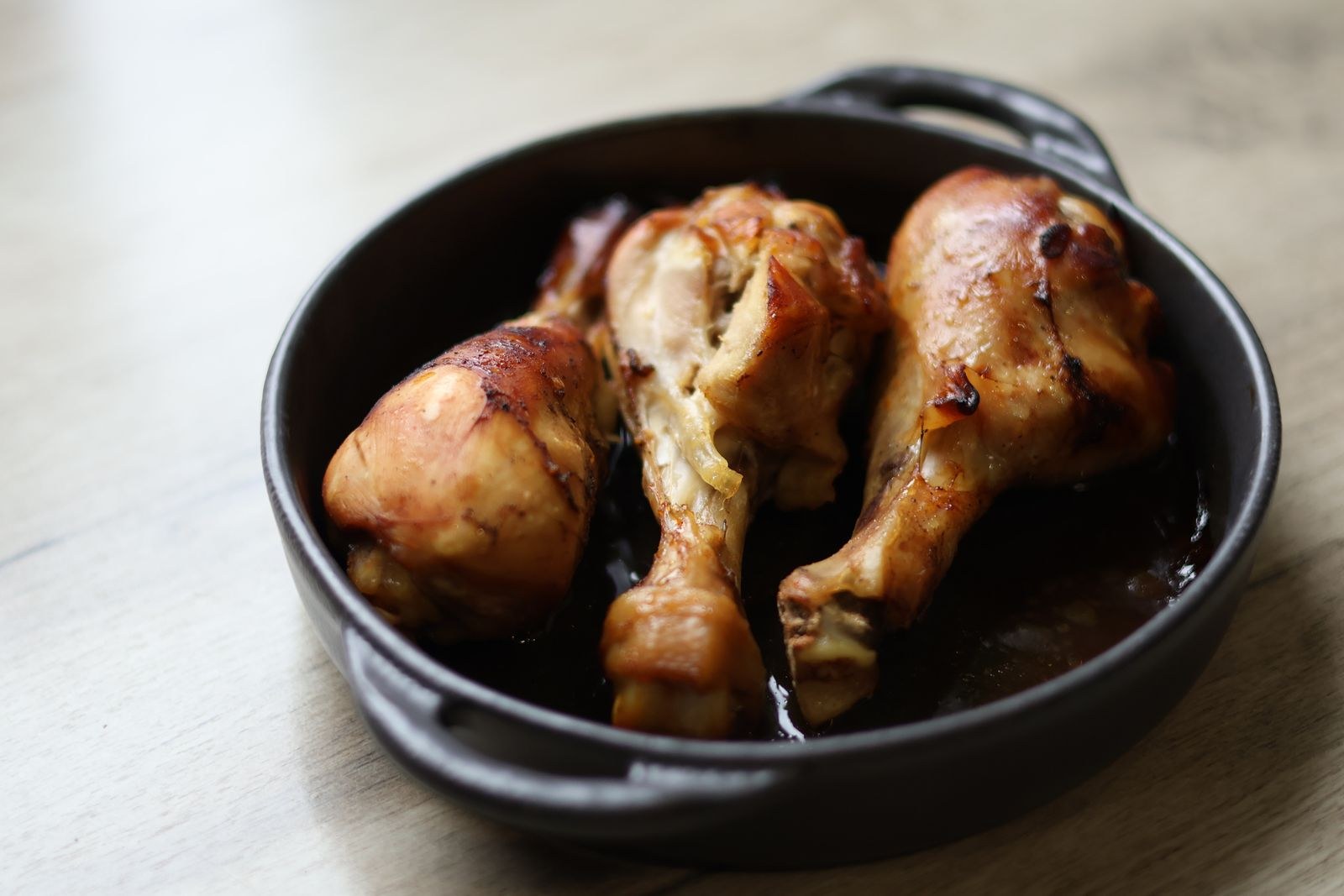 Roasted chicken legs in a black cast iron pan