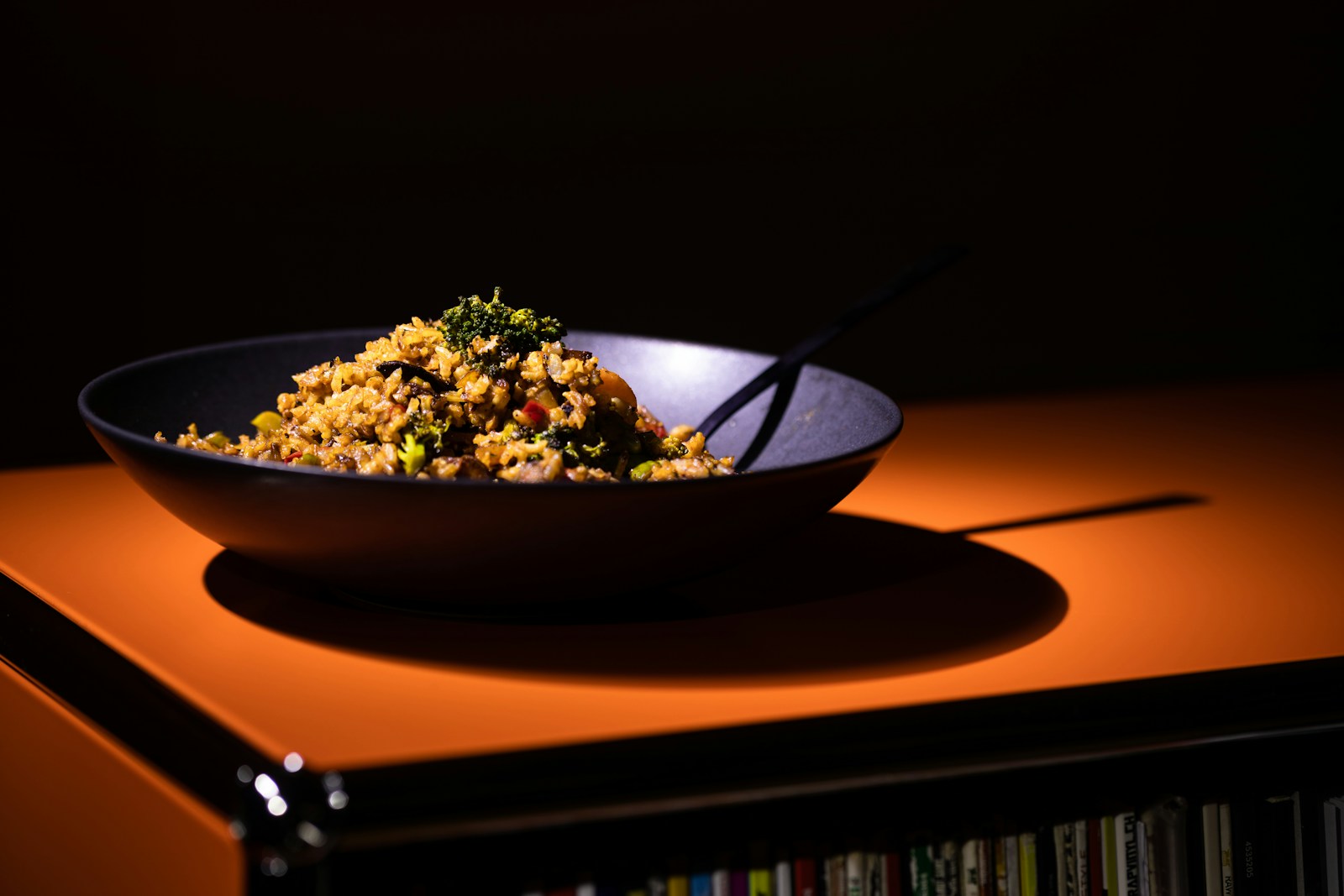 Dark bowl of tiny pasta with greens and herbs
