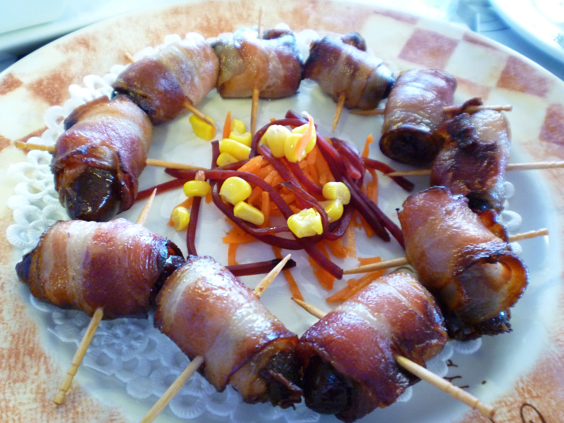 Devils on horseback, bacon-wrapped bites on a dish