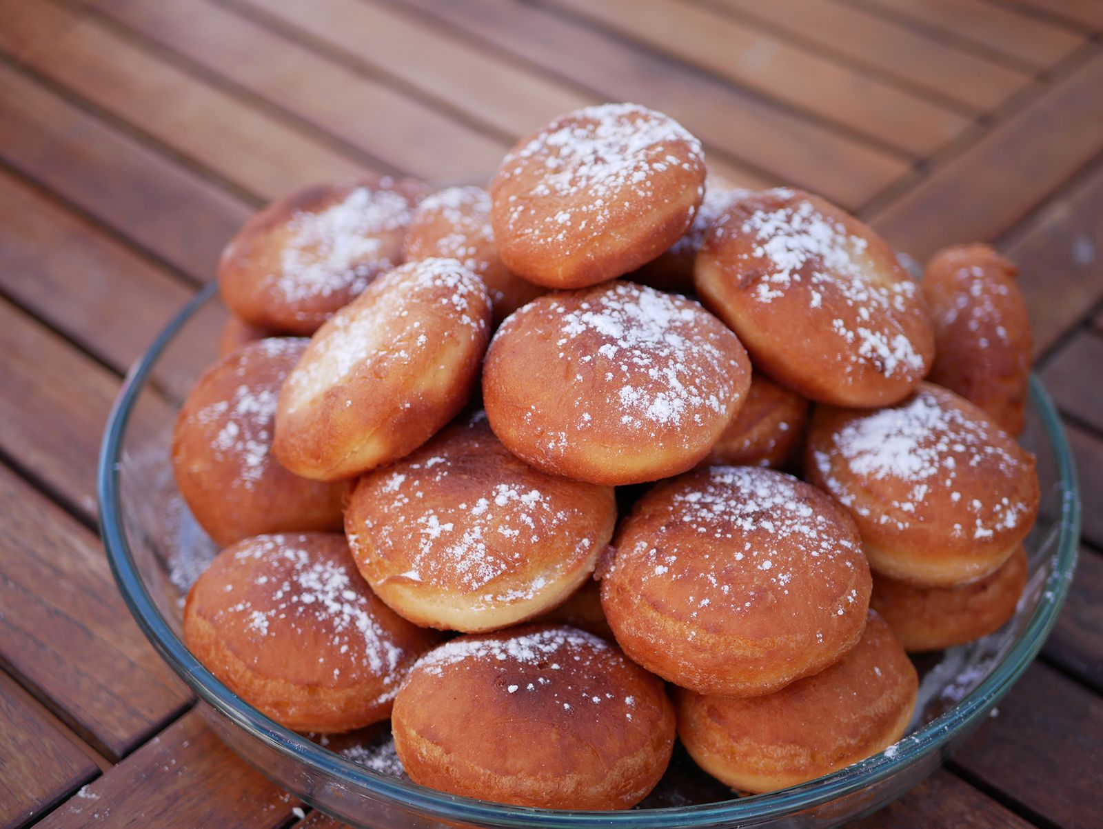 Sugar-dusted fried dough bites in a glass bowl
