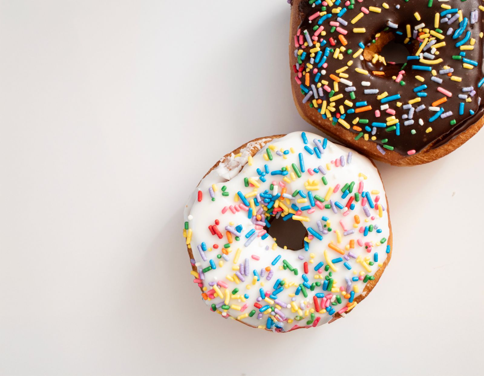 Frosted doughnuts with colorful sprinkles