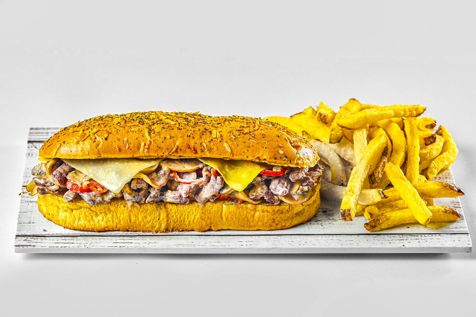 Cheesesteak sandwich on a toasted roll with fries