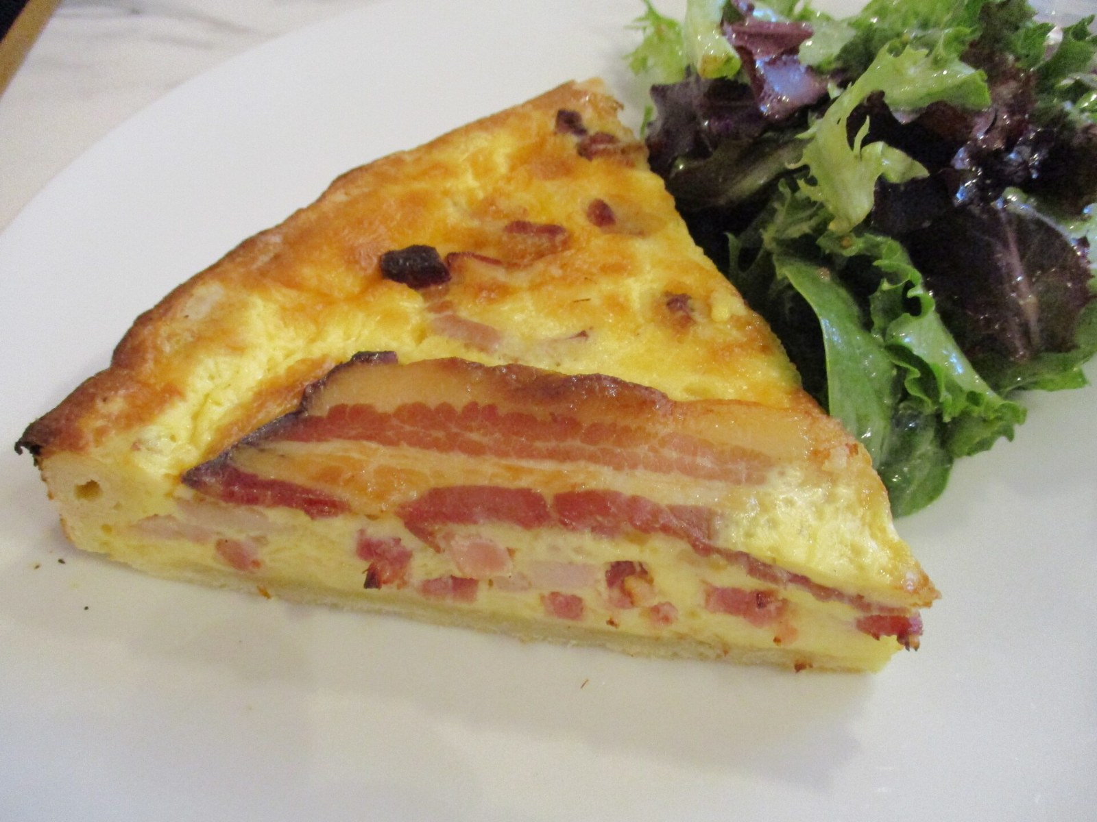 Christmas breakfast casseroles: slice of ham and cheese quiche with salad