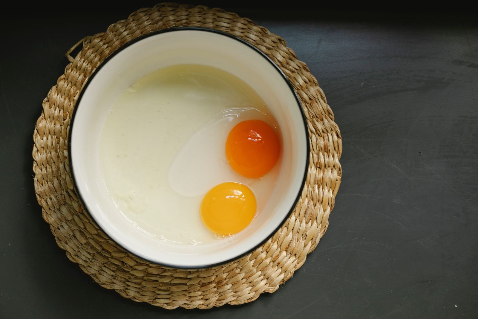 Two raw eggs cracked into a bowl, ready for holiday baking