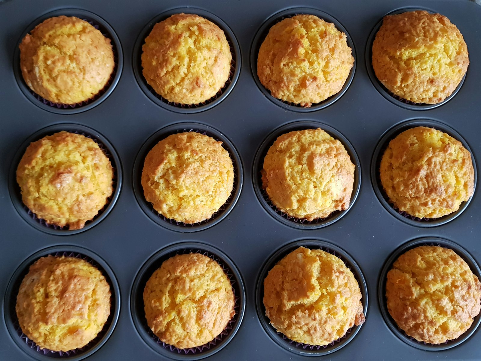 Cornbread recipes in muffin form: golden corn muffins in a dark muffin tin