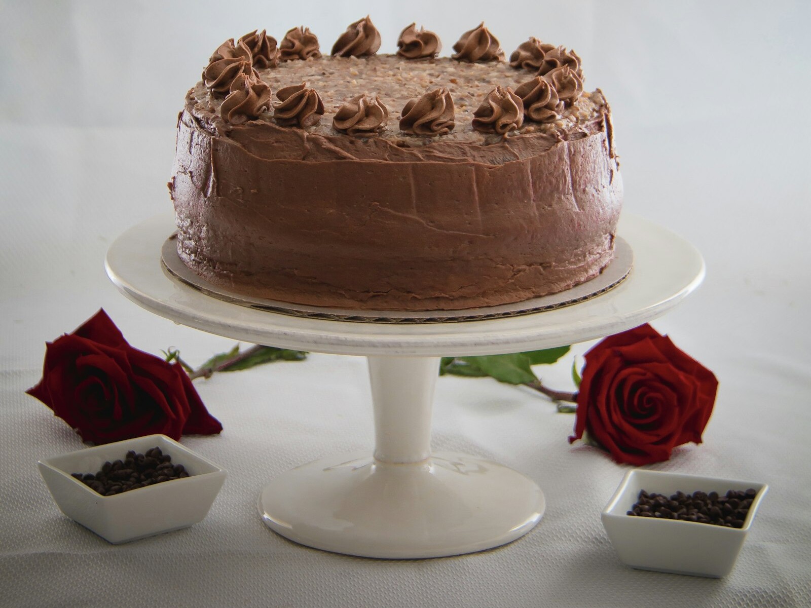 Chocolate cakes like Grandma made: a tall frosted layer cake on a white stand with roses