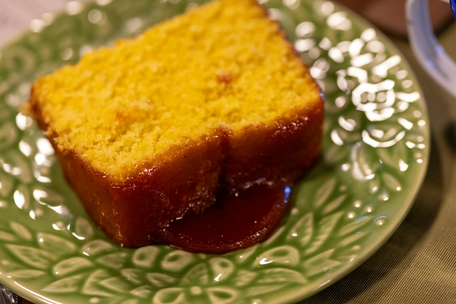 Slice of golden cornbread with a sweet glaze
