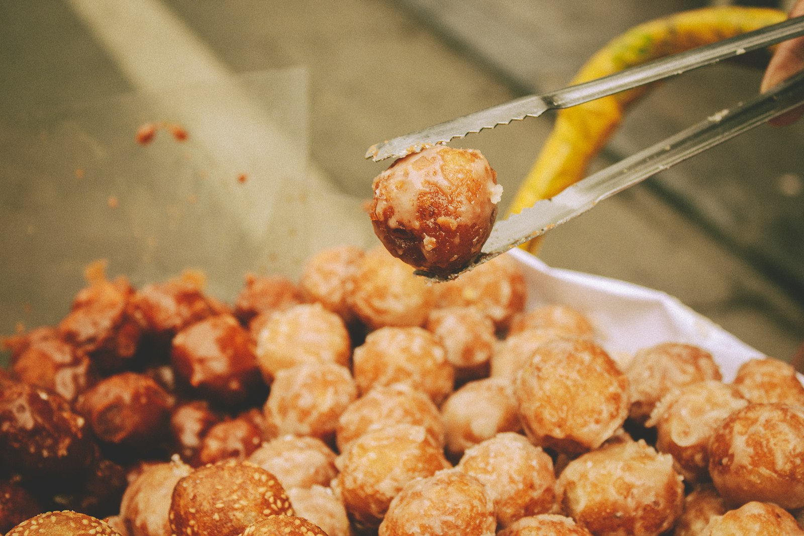 Glazed meatballs picked up with tongs