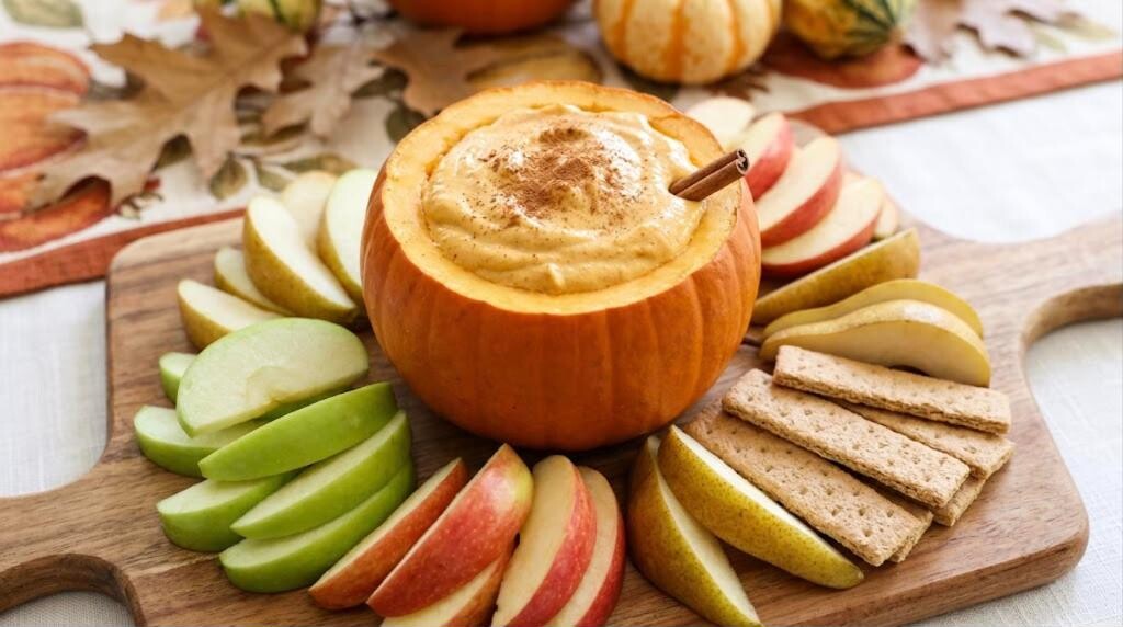 Pumpkin yogurt dip in a mini pumpkin with apple and pear slices