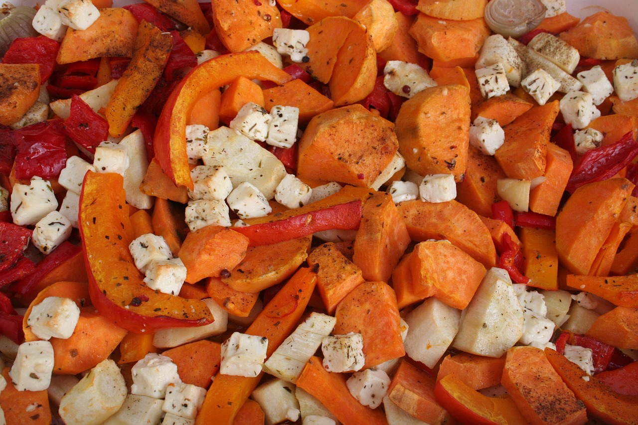 Butternut squash and pumpkin gratin with crumbled cheese in a baking dish