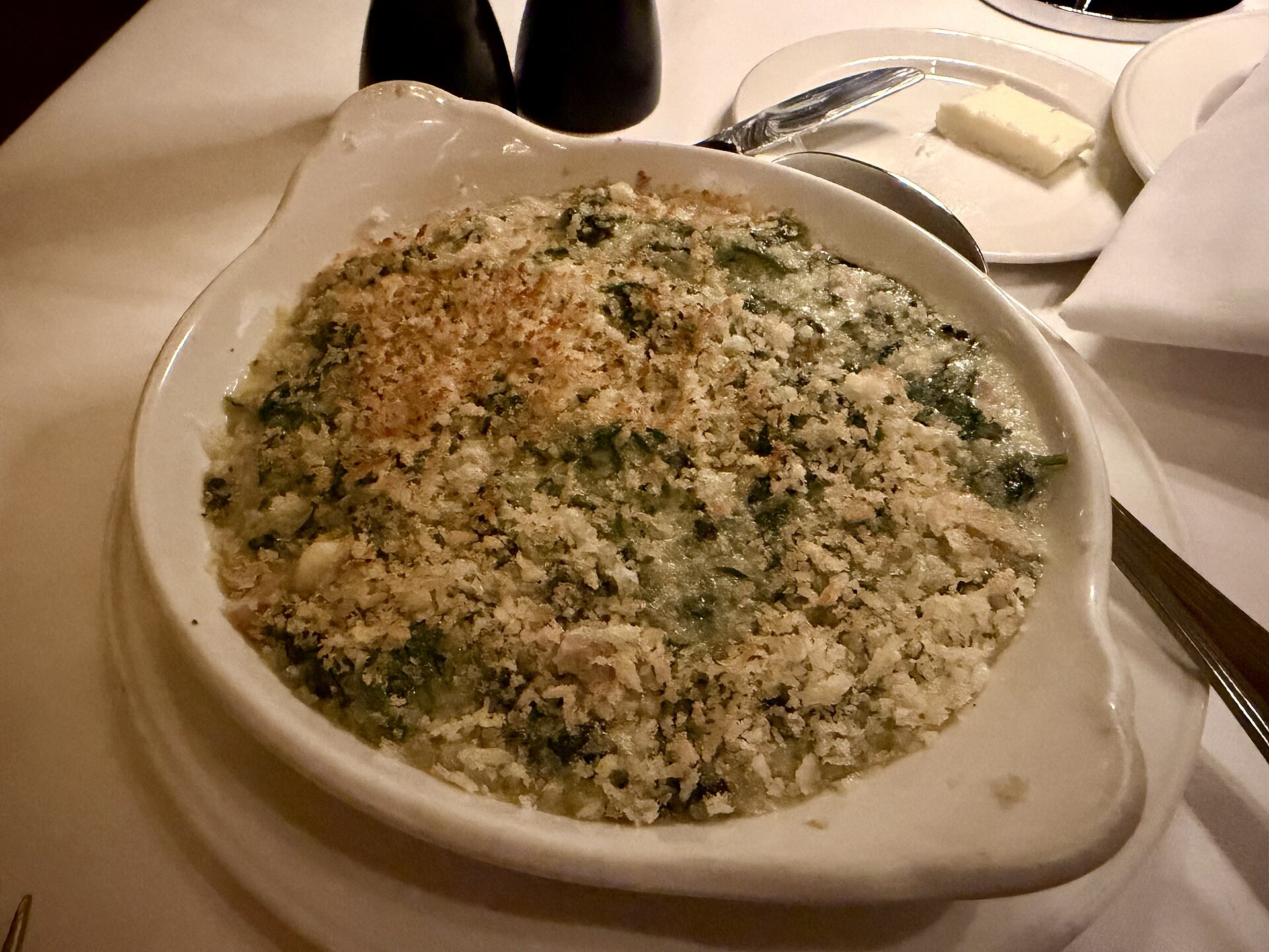 Creamed spinach with a golden crumb topping served at a steakhouse