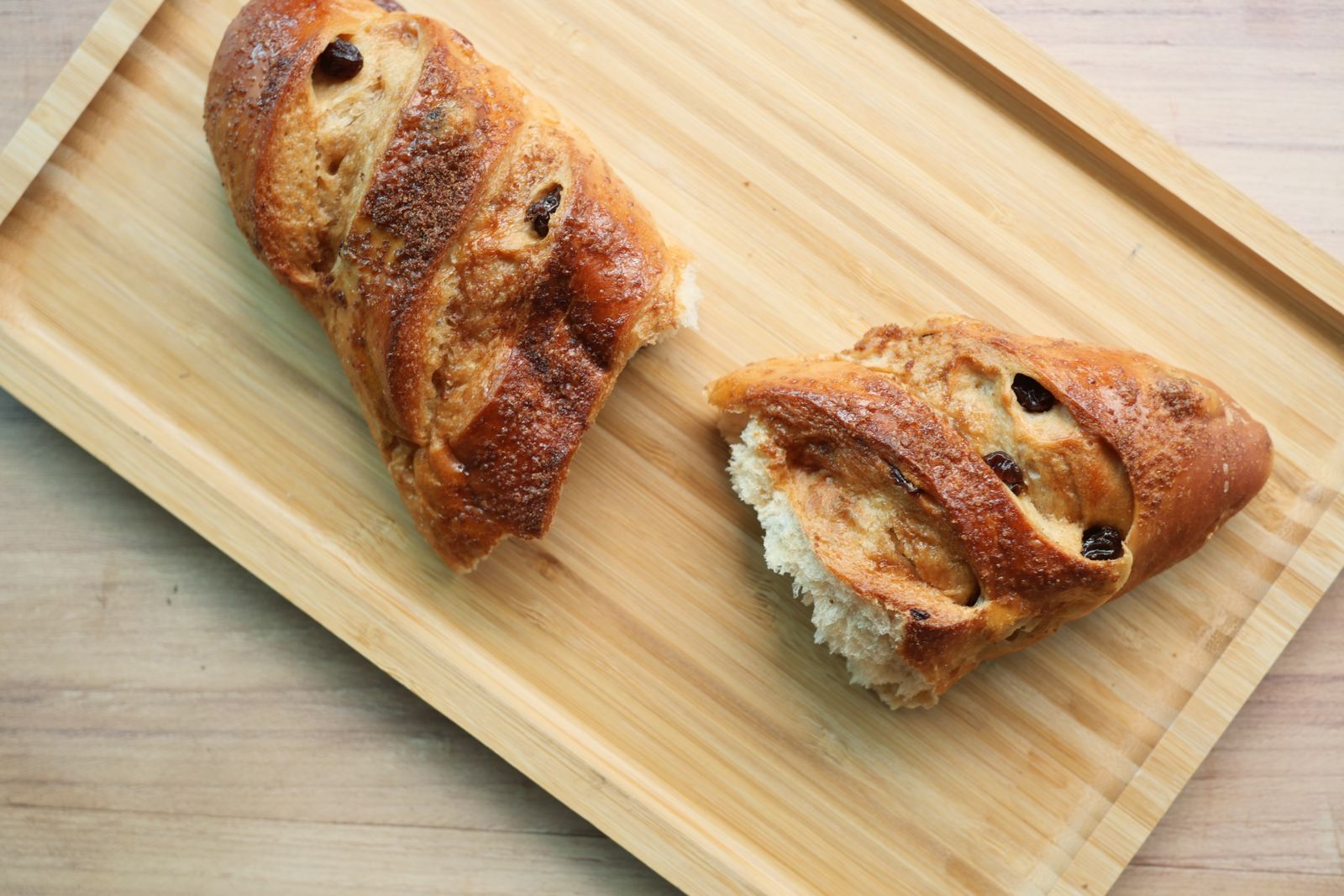 Braided sweet bread with dried fruit on a wooden board