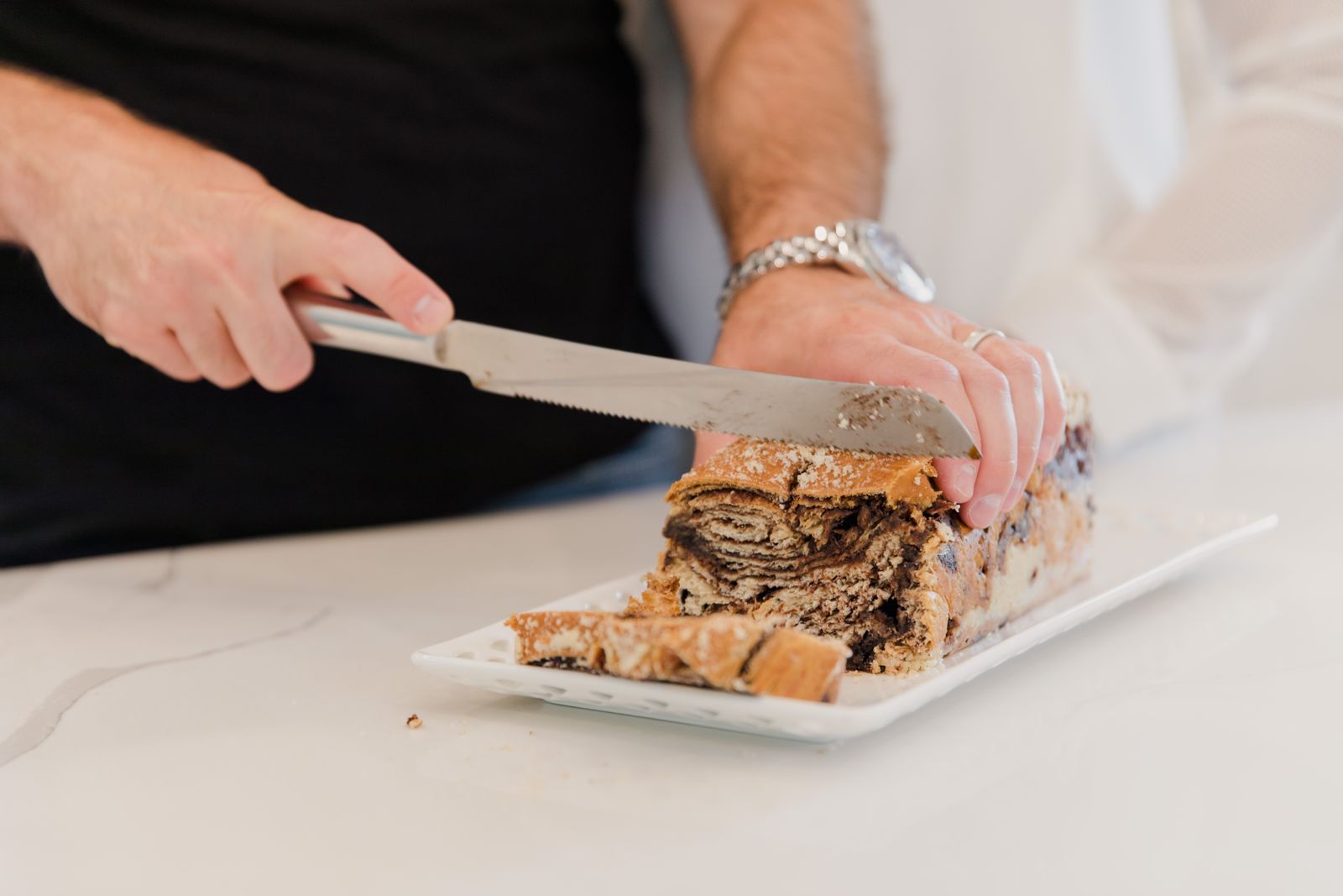 Slicing a chocolate swirl loaf on a white board