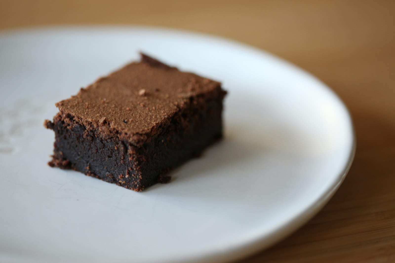 Fudgy chocolate brownie on a white plate, a butter vs oil favorite