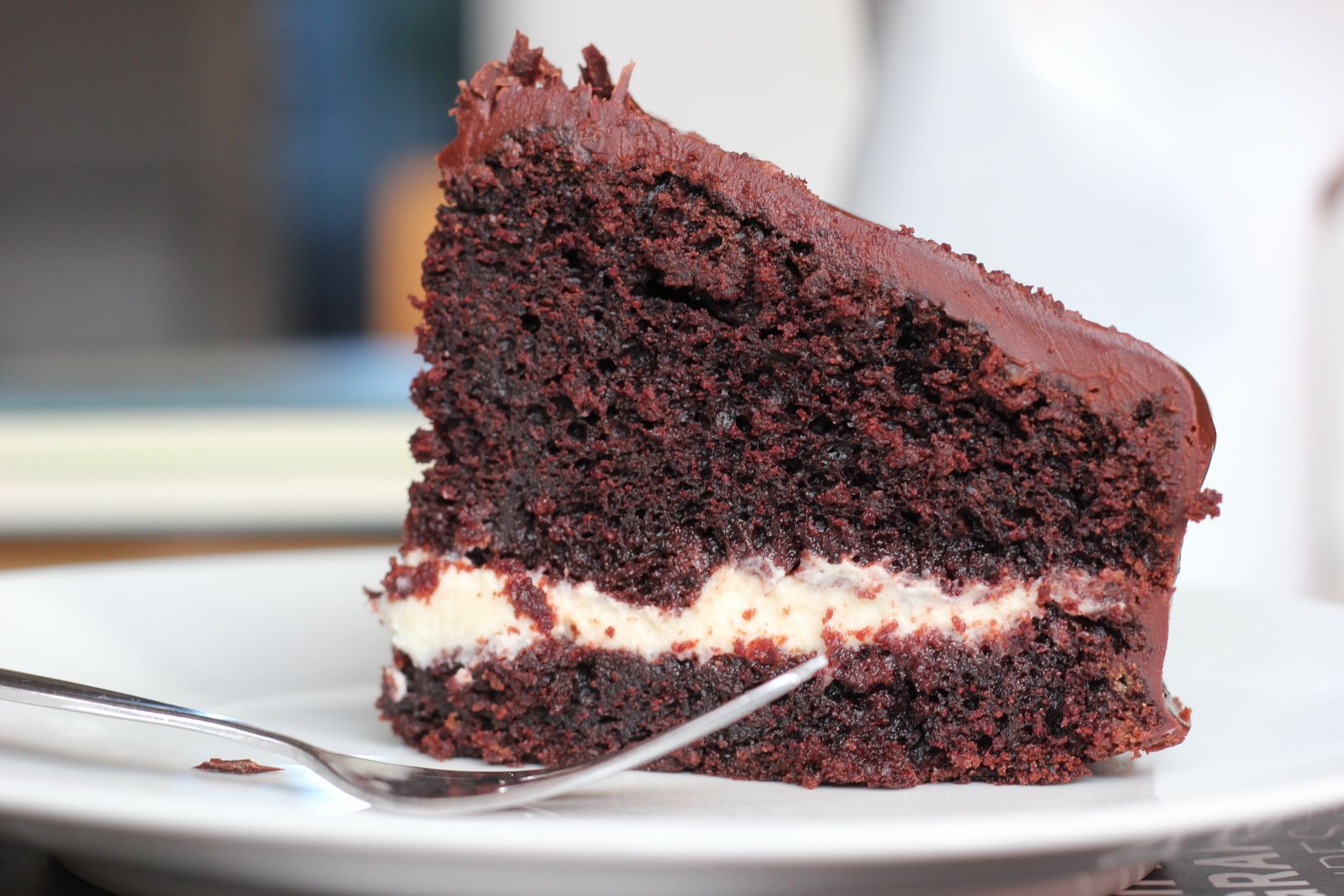 Slice of moist chocolate layer cake on a plate, made with oil in the butter vs oil test