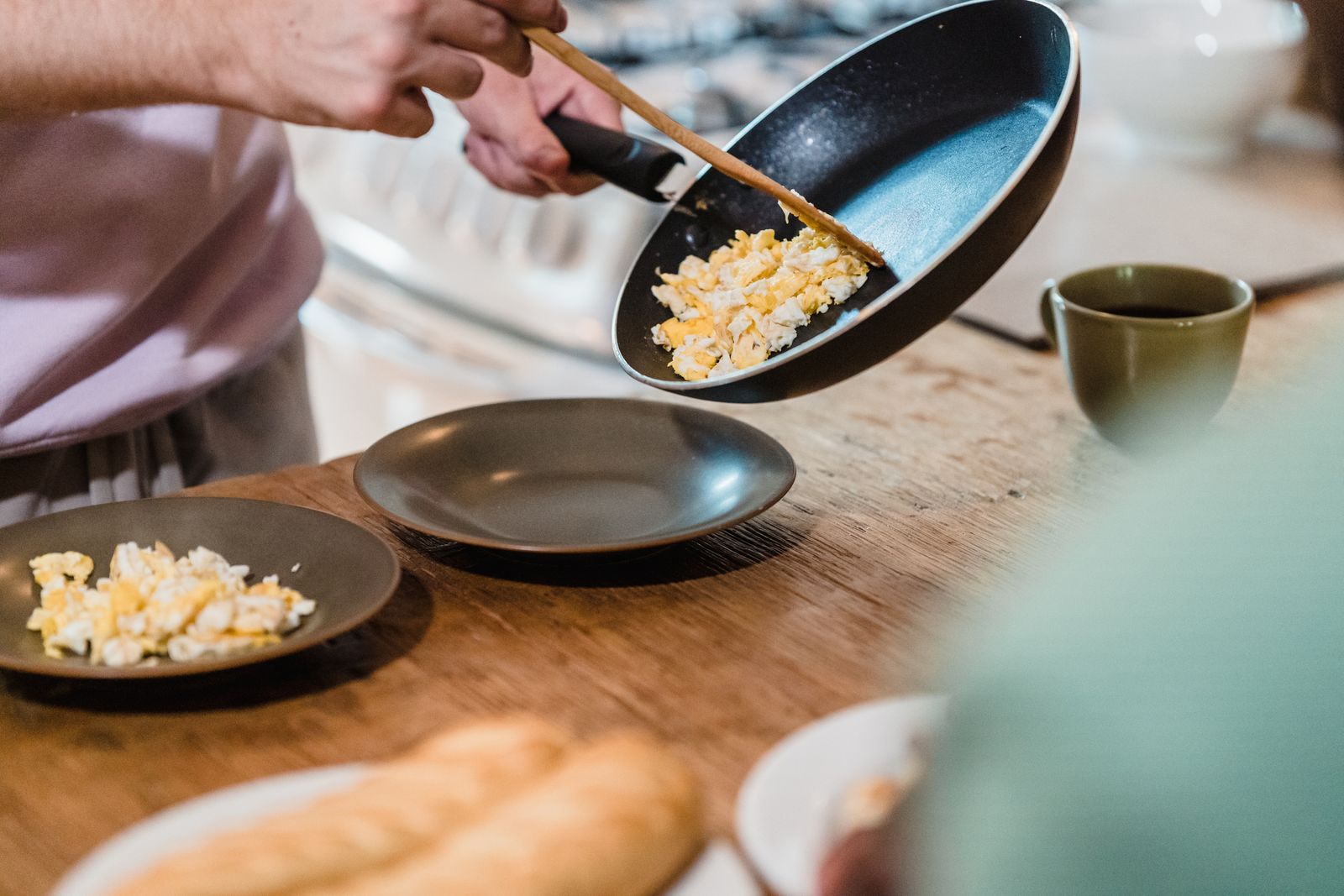 Soft scrambled eggs cooked in butter being served from the pan, a clear butter vs oil win