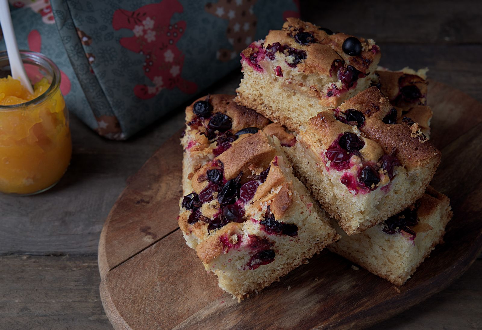 Squares of cranberry orange bread on a wooden board