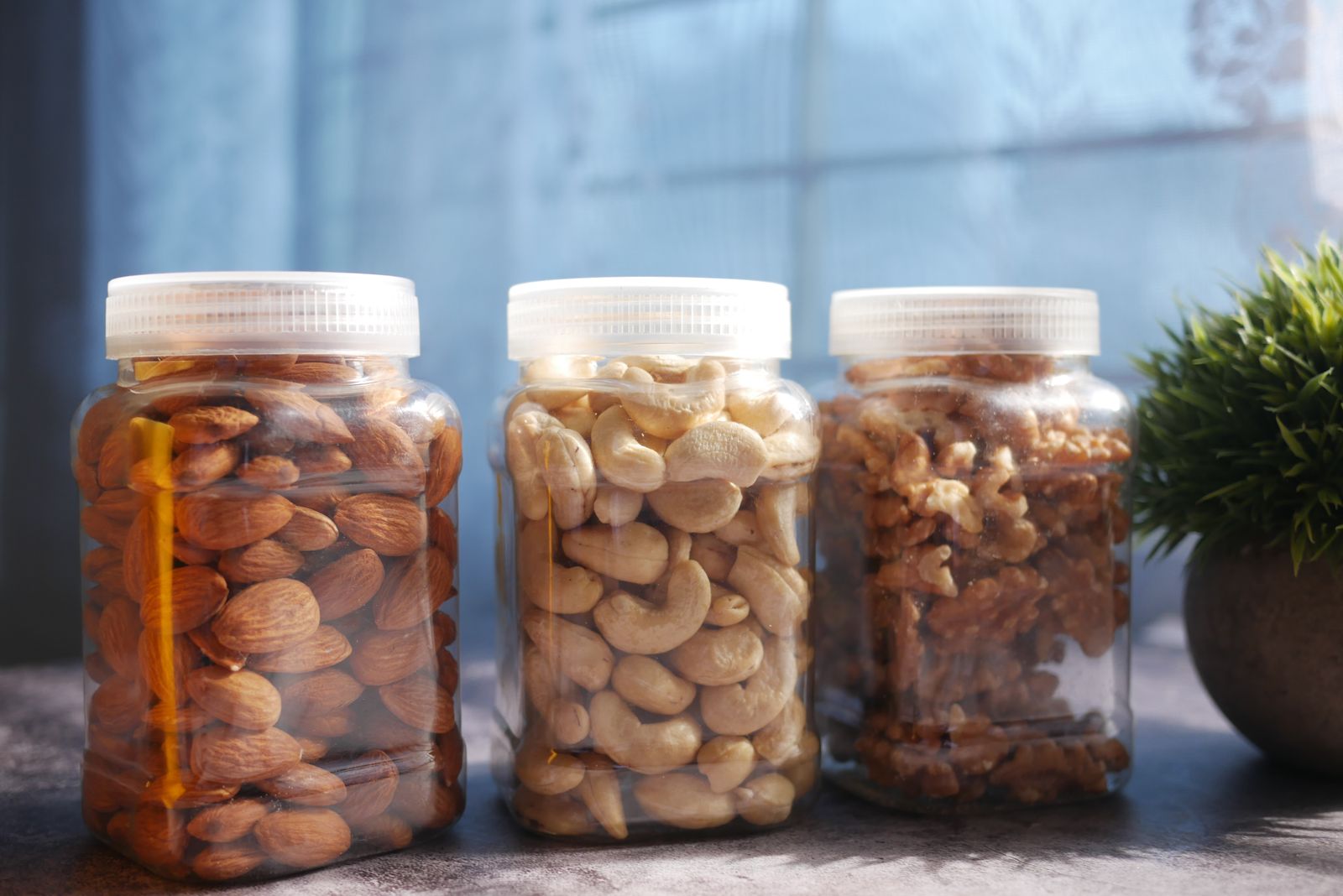 Three clear jars filled with spiced nuts for holiday baking gifts