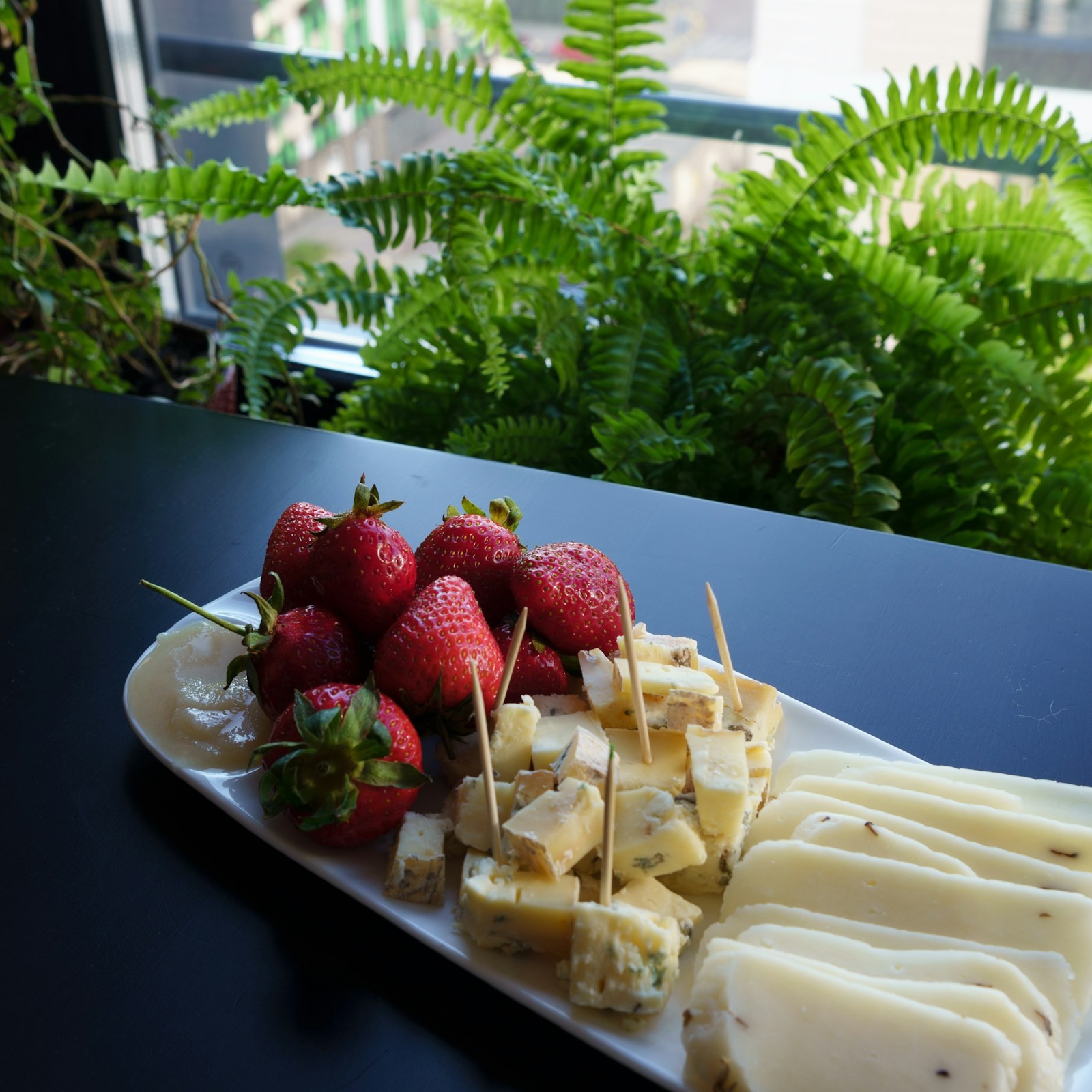 Cheese cubes and strawberries on cocktail picks on a long platter