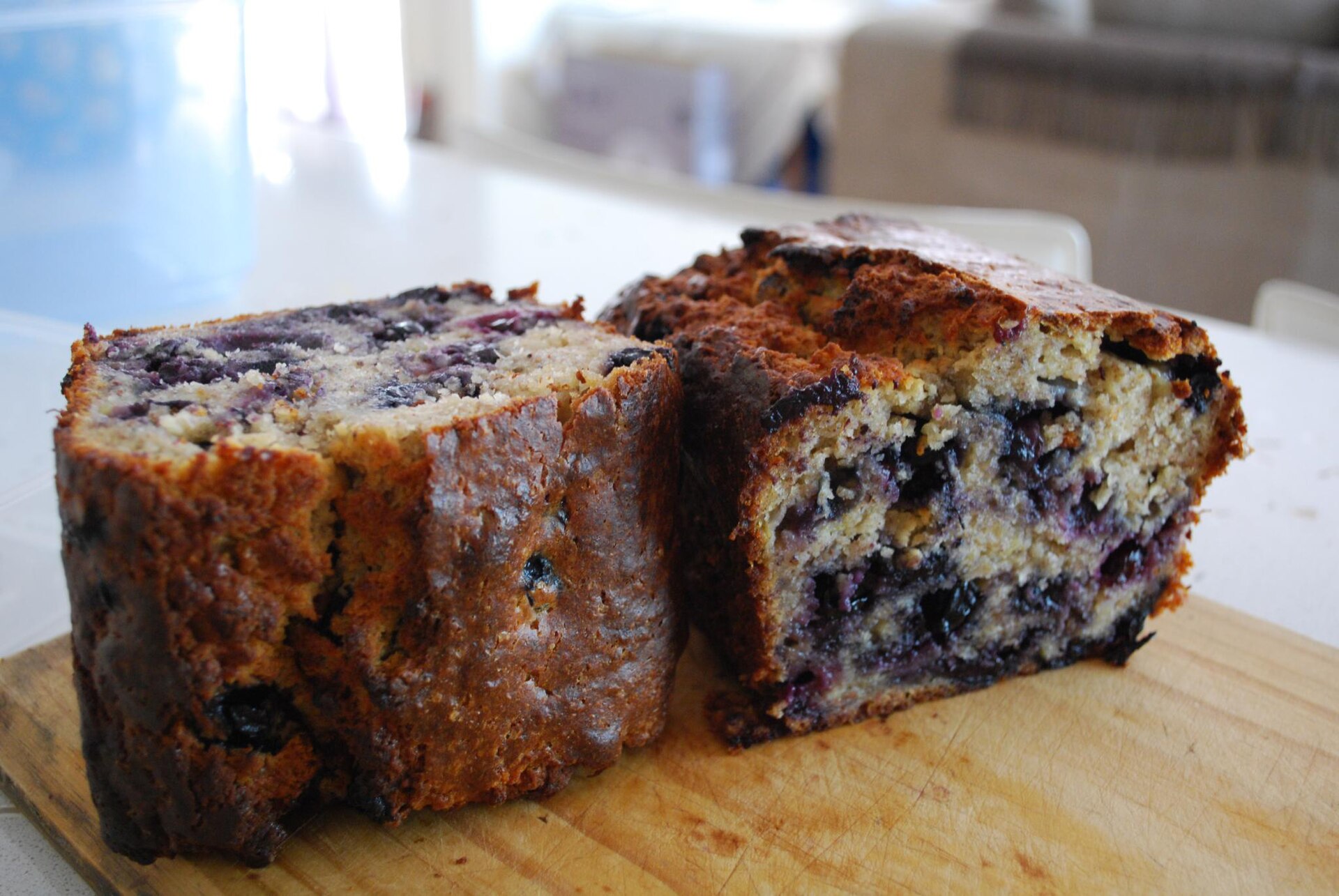 Two thick slices of homemade banana bread with blueberries and walnuts