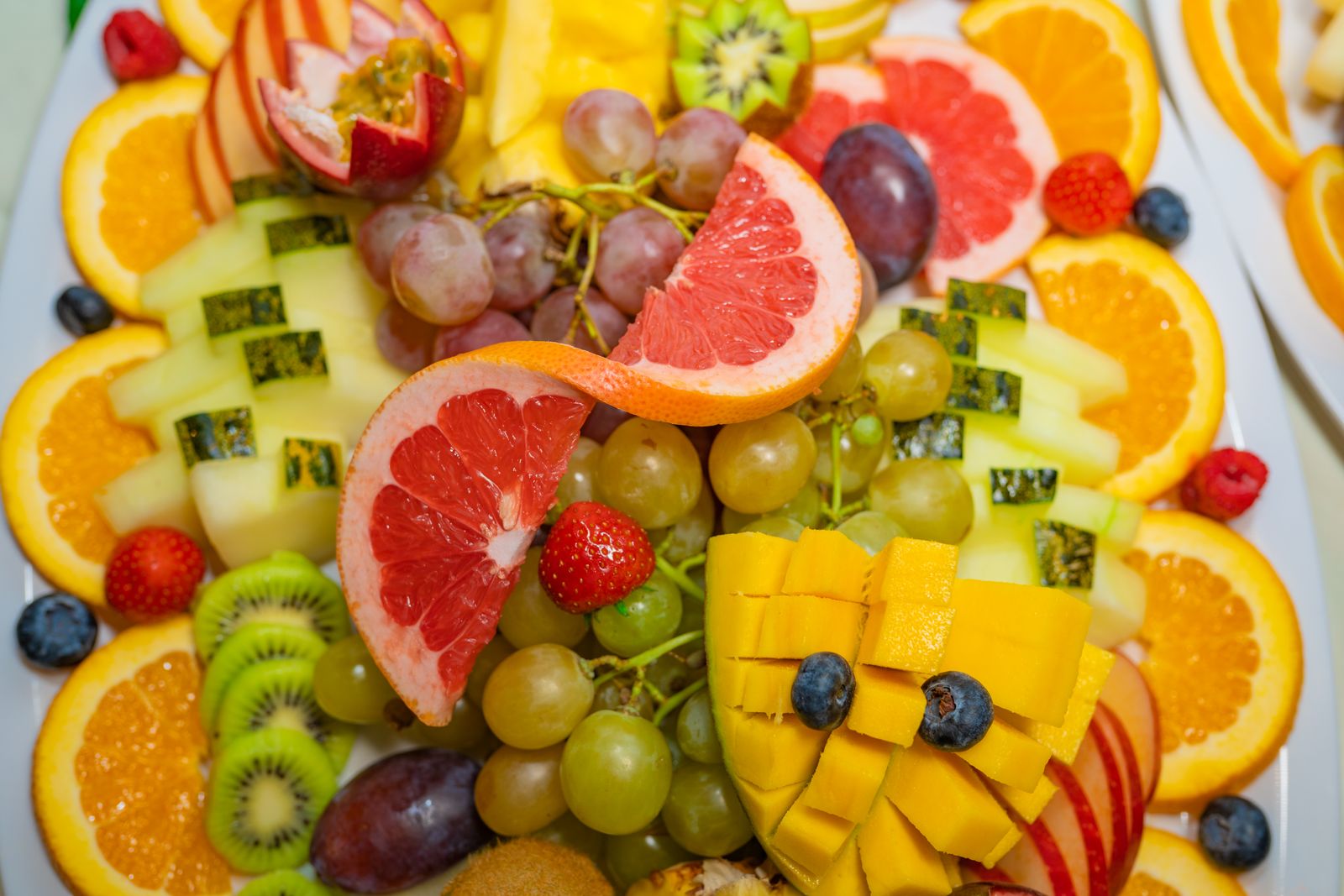 Big tropical fruit platter with oranges, kiwi, grapes and berries