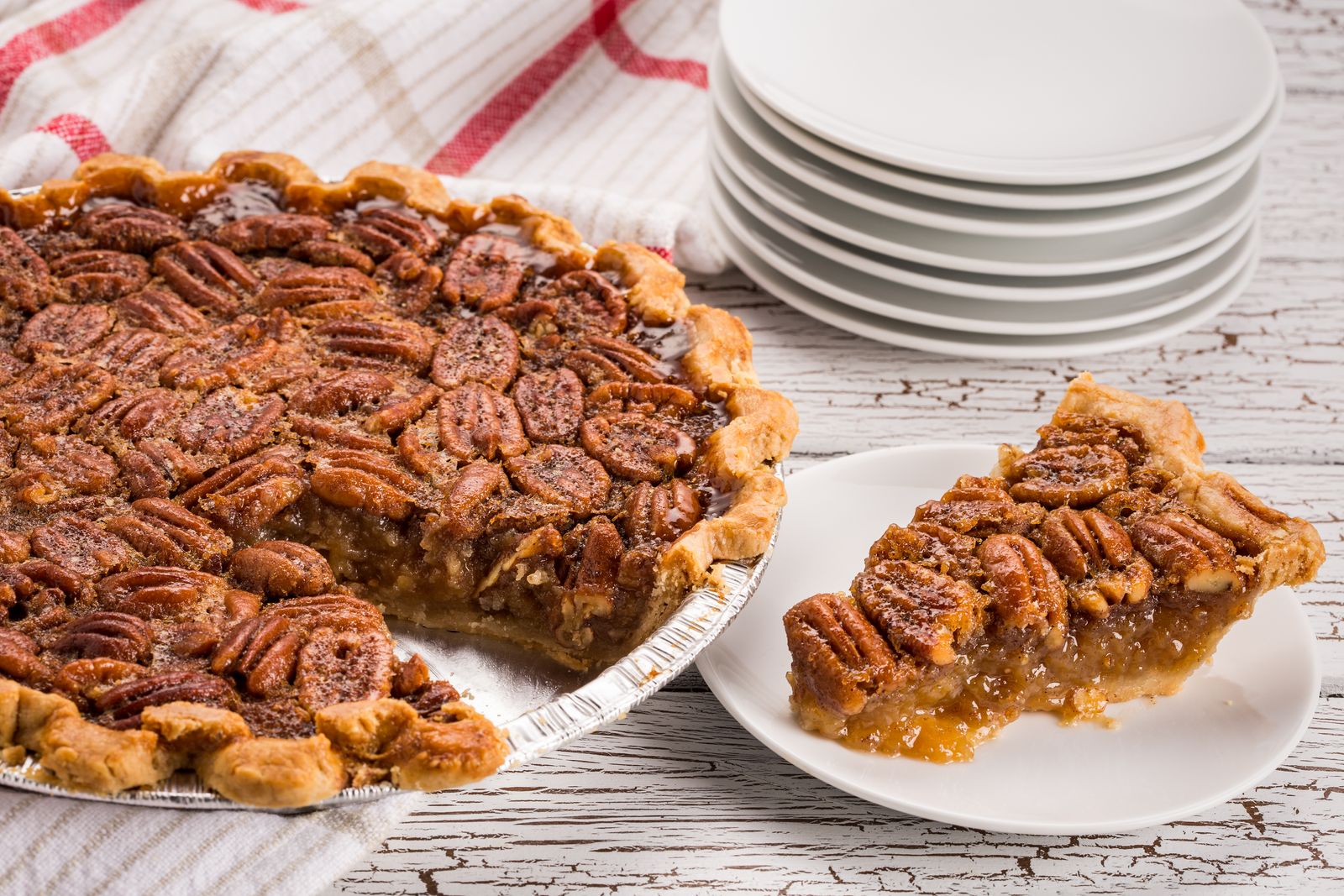 Pecan pie with a slice cut out on a white plate