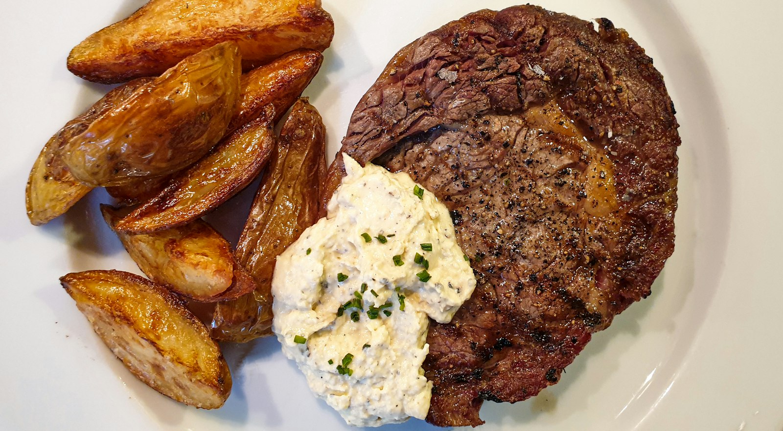 Ribeye with potato wedges and herb butter, an easy steak and potato dinner