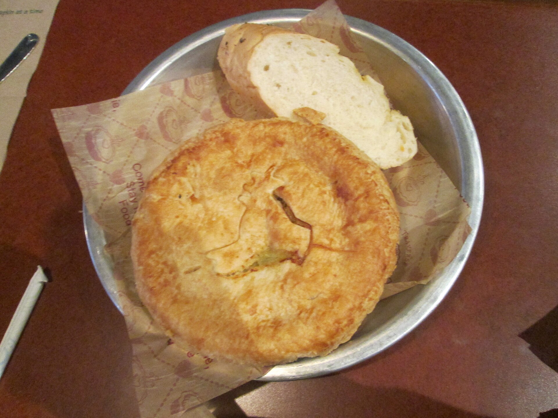 Individual chicken pot pie with a golden crust in a tin