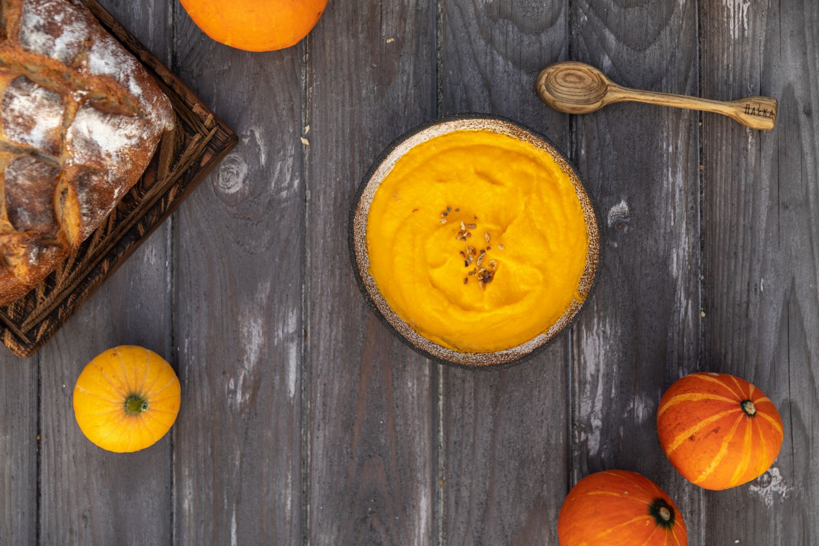Bowl of creamy pumpkin soup on a dark wooden table, cozy Gilmore Girls recipes for fall