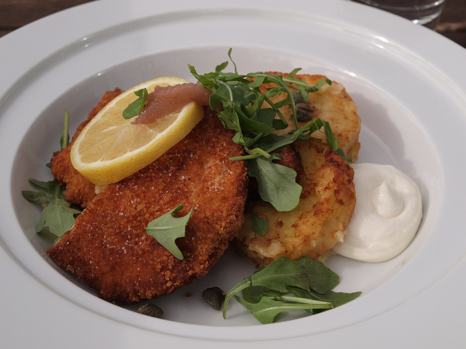Golden Wiener schnitzel with lemon on a white plate