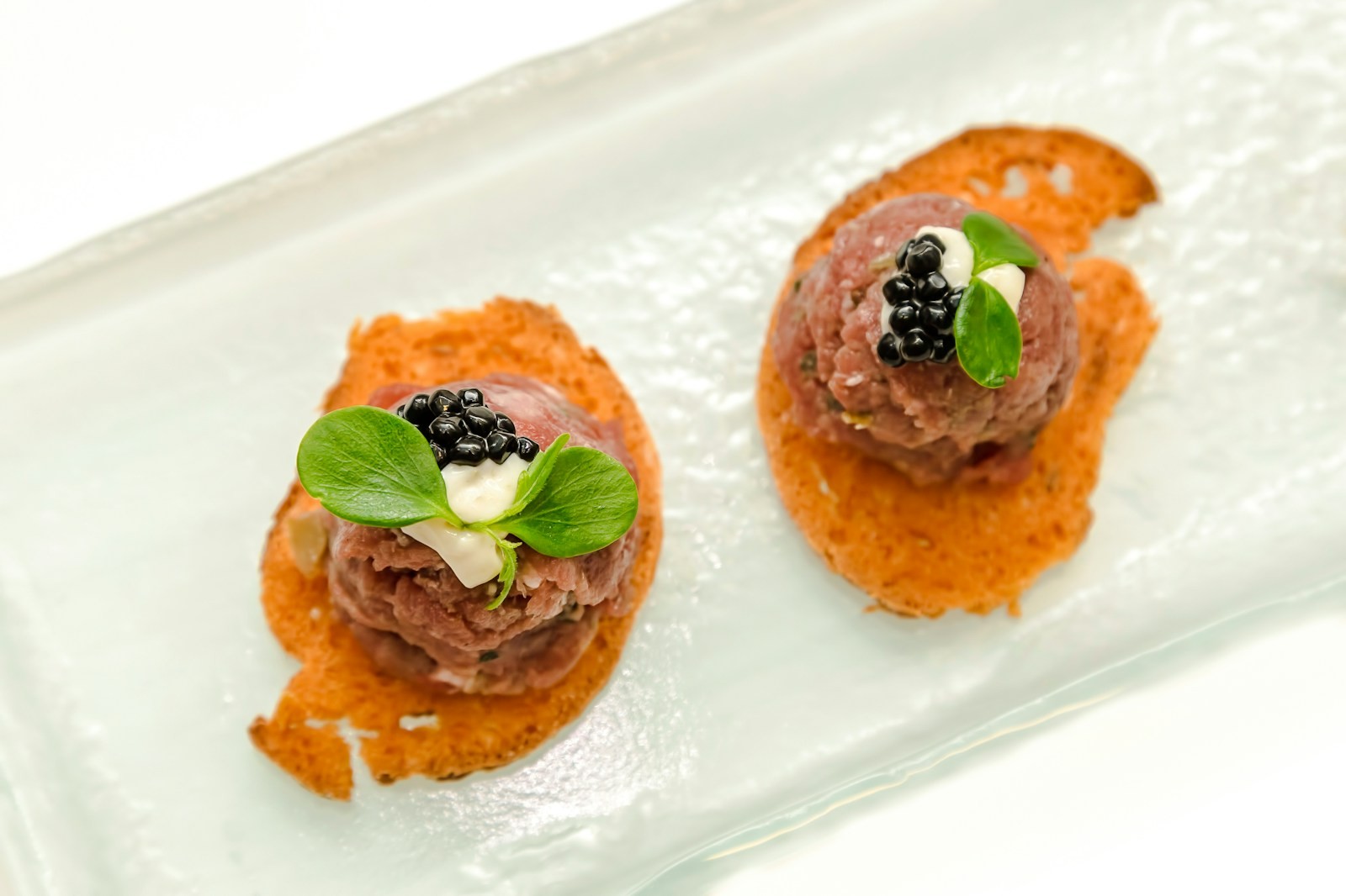 Steak tartare on crispy toasts with caviar and herbs