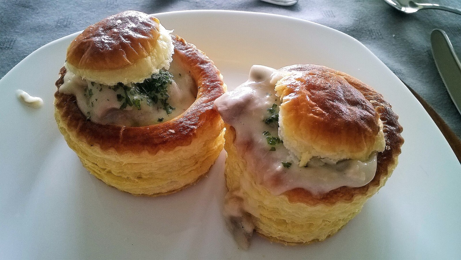 Two puff pastry vol-au-vents filled with creamy chicken ragout