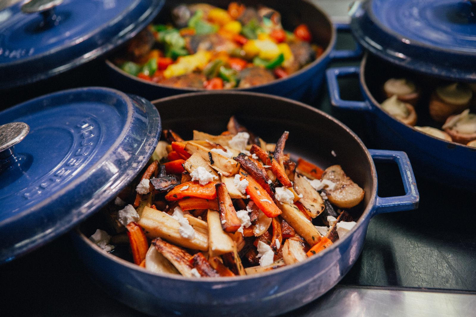 Roasted carrots and vegetables in a blue pan