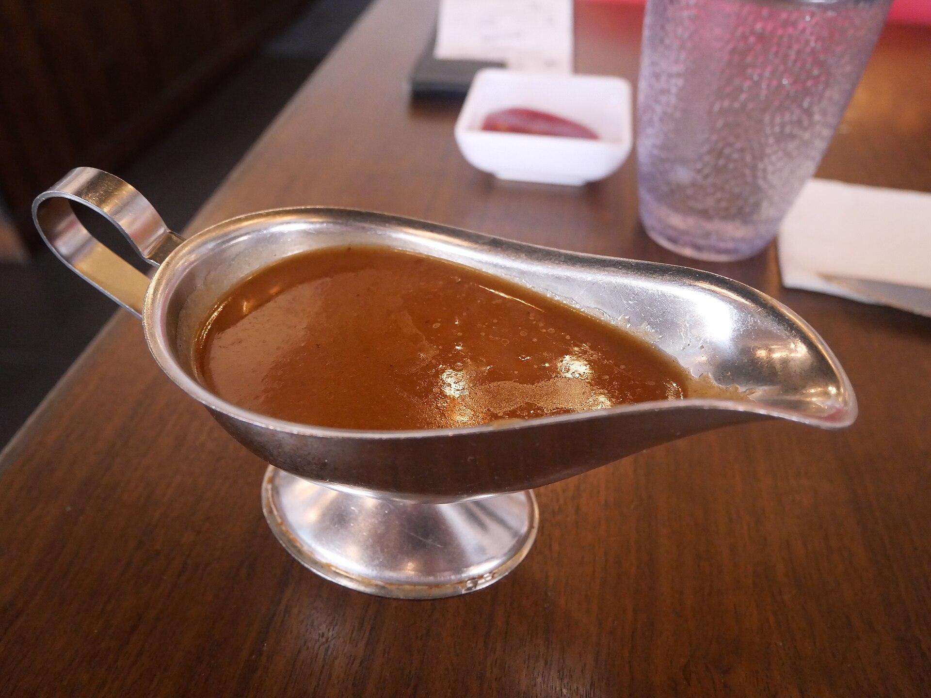 Rich brown gravy in a silver gravy boat