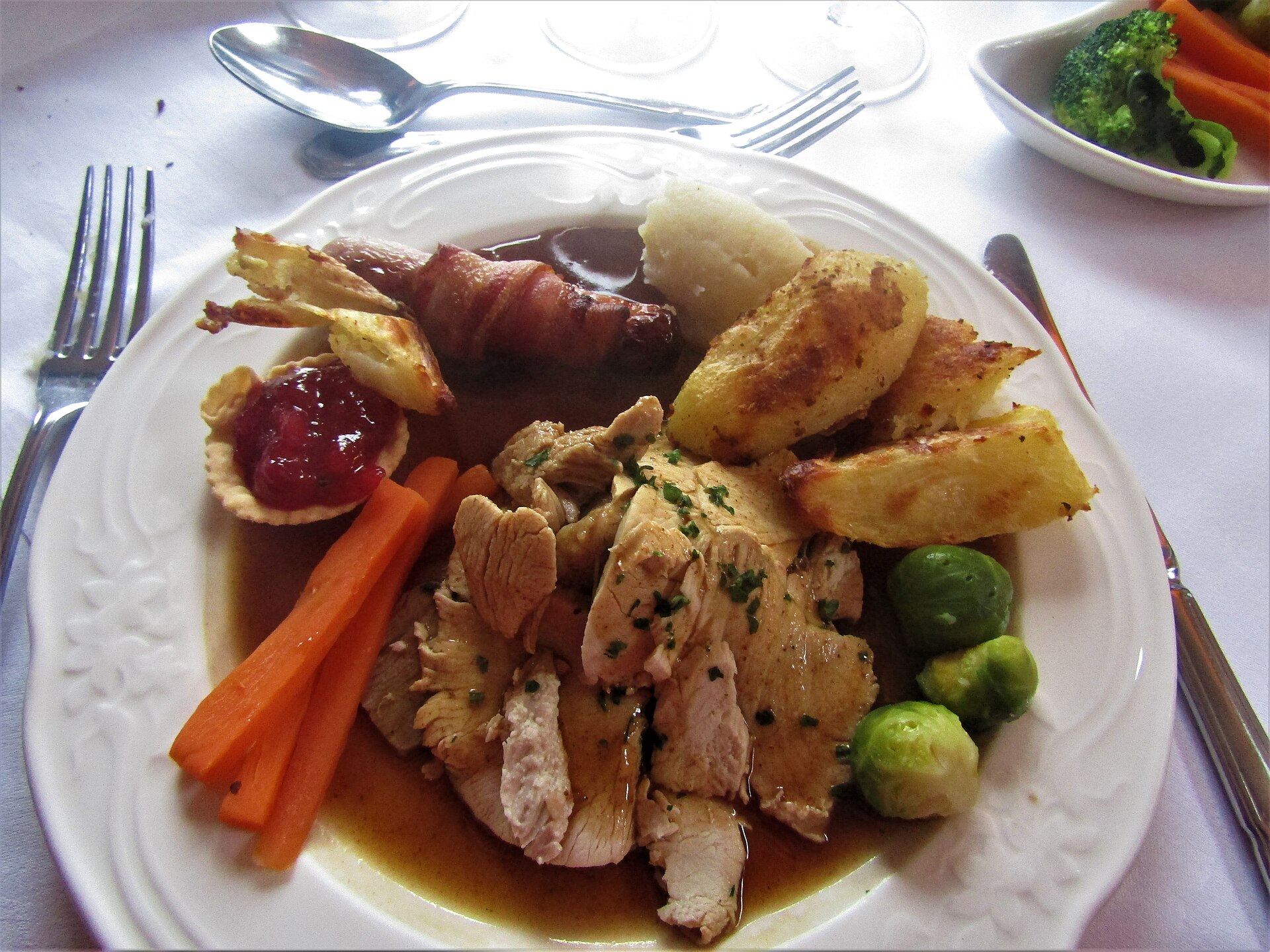 A full British Christmas dinner plate with turkey, pigs in blankets, stuffing and gravy