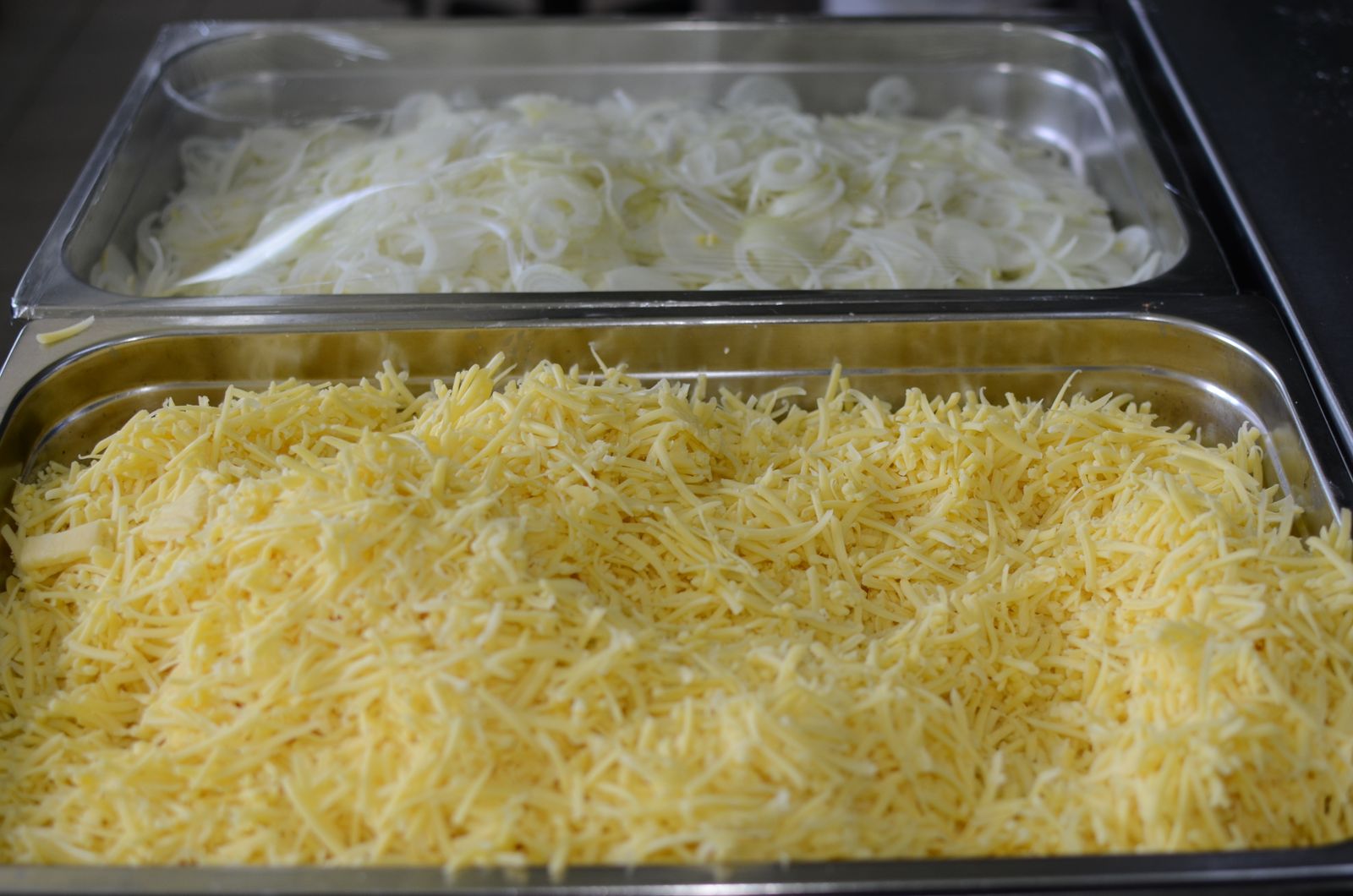 Trays of freshly shredded cheese ready for baking
