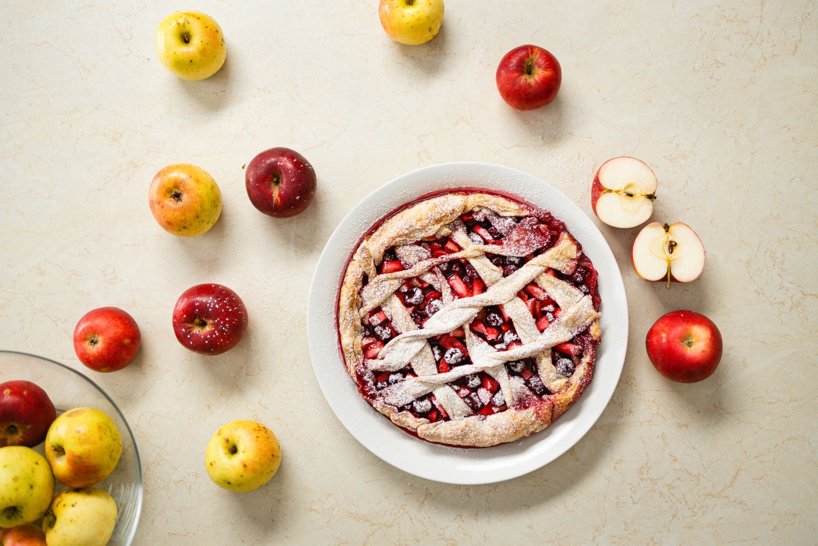 Lattice apple pie surrounded by fresh apples
