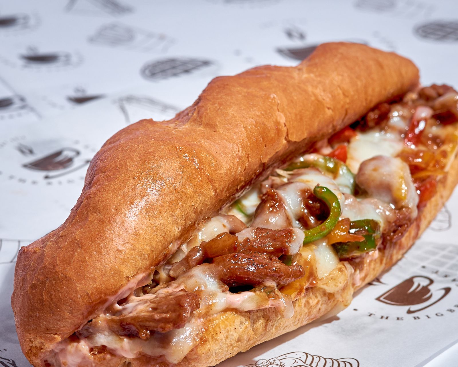 Long roll stuffed with shaved meat, peppers and melted cheese