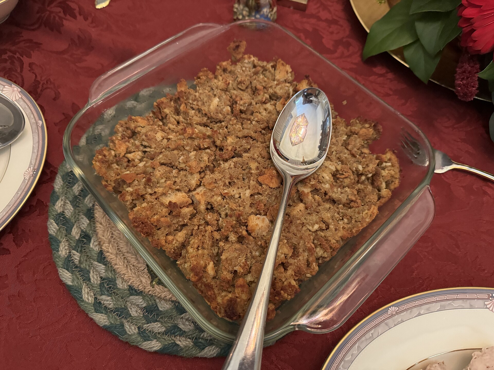 Golden baked stuffing in a glass dish with a spoon