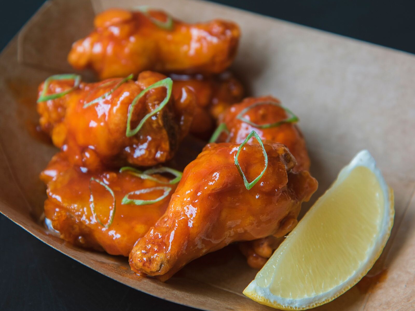Saucy buffalo chicken wings with a lemon wedge for game day at a Kelce Thanksgiving