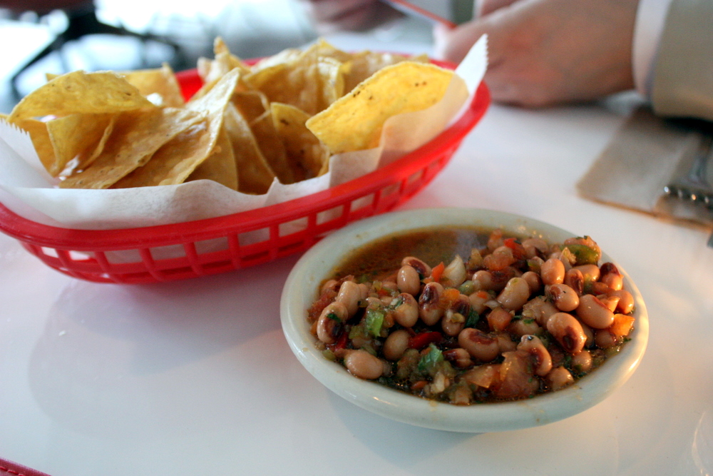Bowl of Texas caviar black-eyed pea salad with tortilla chips, one of the fresh Texas Thanksgiving recipes