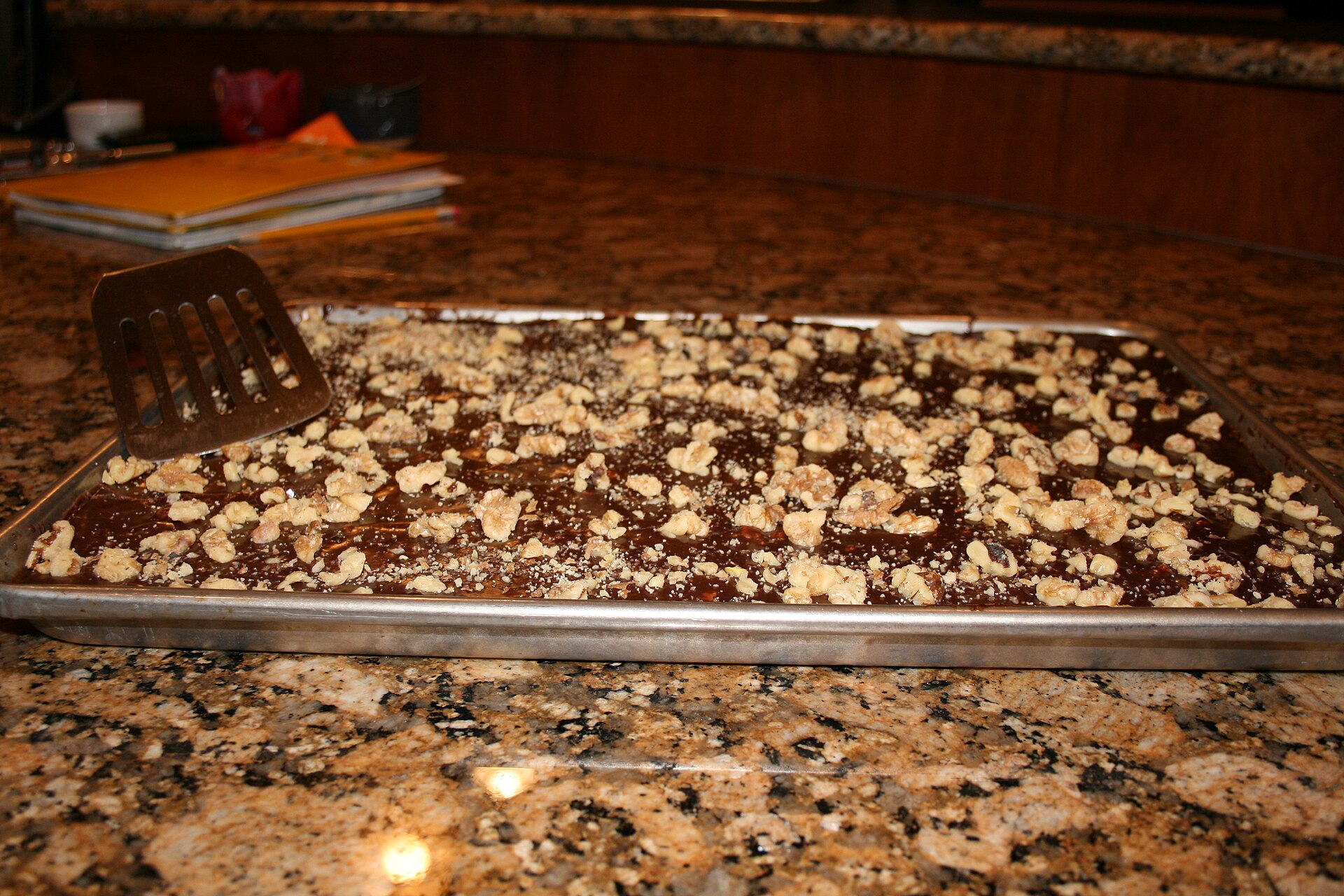 Chocolate Texas sheet cake with fudge icing and chopped pecans in a pan
