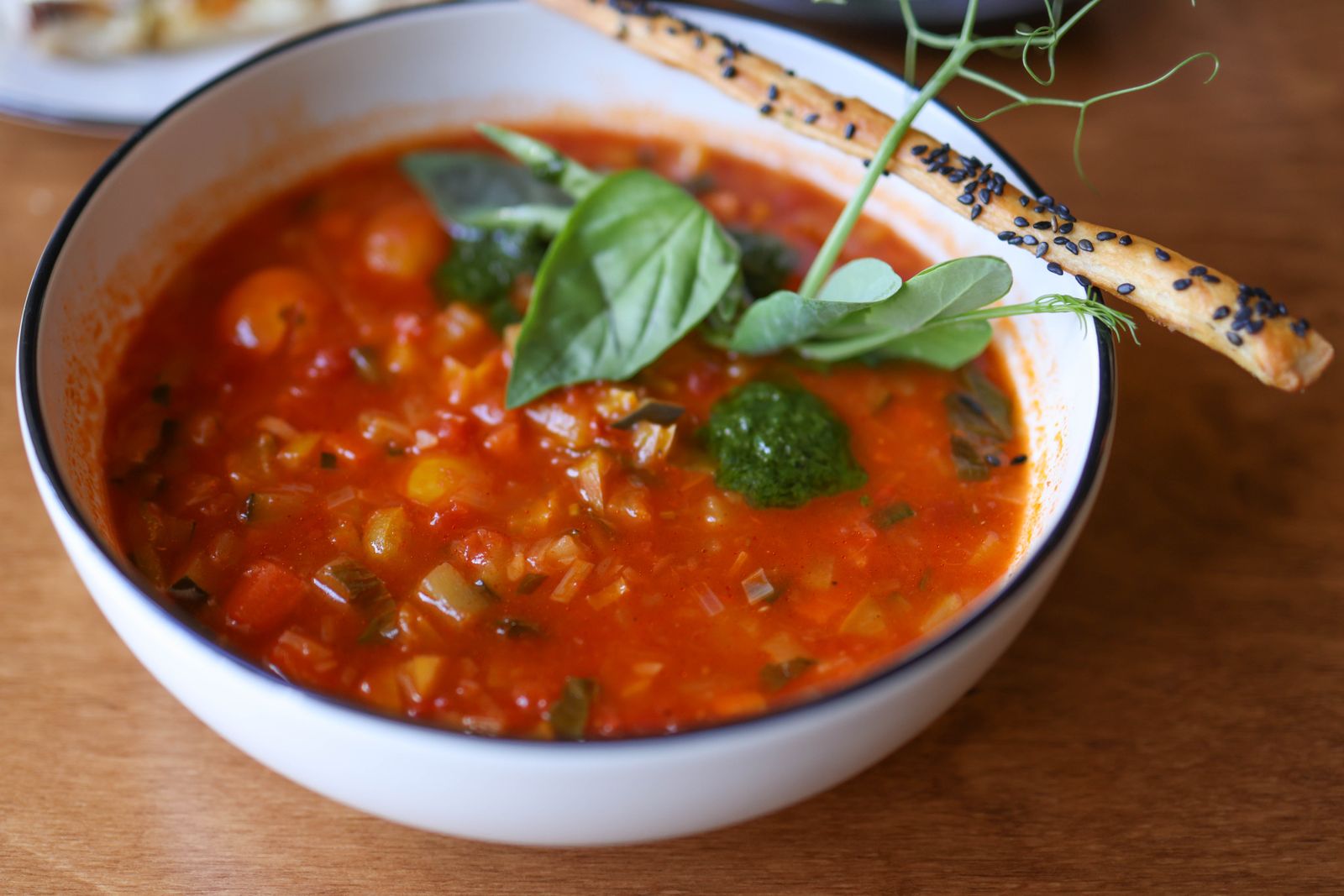 Bowl of tomato pasta e fagioli with beans and fresh basil